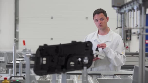 Plastik kalıpların doğru ölçümü için uzaktan kumanda makinesi kullanan kalite mühendisi kontrolü, otomotiv endüstrisi için far üretimi — Stok video