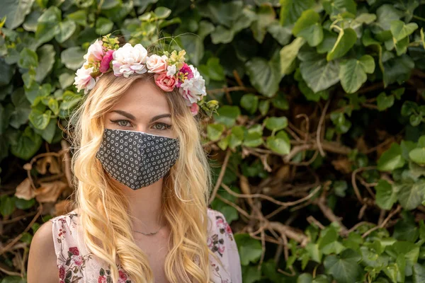 Svatební portrét ženy v šatech s květinovým věncem na hlavě a maskou na ústech. opatření v době epidemie koronaviru — Stock fotografie