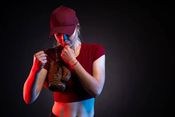 Portrét ženy se starými boxerskými rukavicemi na černém pozadí, kopírovací prostor — Stock fotografie