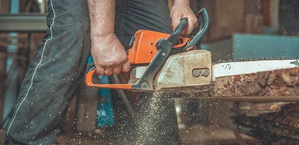 Motosega manuale nelle mani di un falegname taglio legno — Foto Stock
