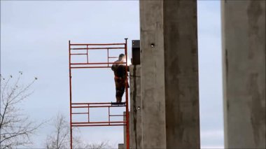 Yükseklik büyük alışveriş karmaşık metal yapılar ve beton kazık yapımında çalışan bir kaynakçı