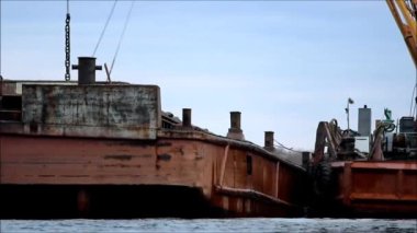 Suyla ilgilen. Bir yükleyici bir mavnadan bir gemiye kömür yükler. rapor çekimi.