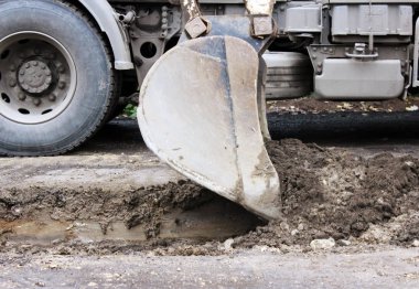 Kazı kovasının kirli işleri, kazıyor ve zemini yerle bir ediyor.