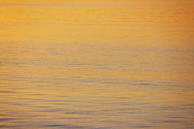 Arka planda batan güneşin altın ışınlar nehrindeki su. Maviye altın