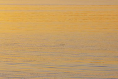 Arka planda batan güneşin altın ışınlar nehrindeki su. Maviye altın
