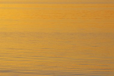 Arka planda batan güneşin altın ışınlar nehrindeki su. Maviye altın