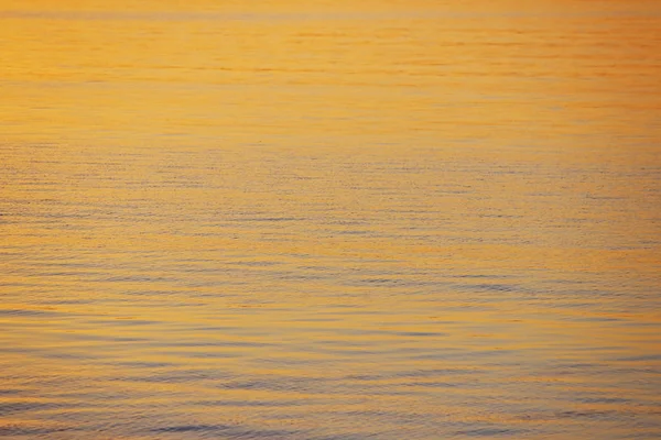 Arka planda batan güneşin altın ışınlar nehrindeki su. Maviye altın