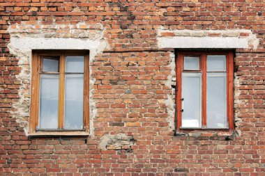 Eski tuğla duvar ve arka planda iki pencere.