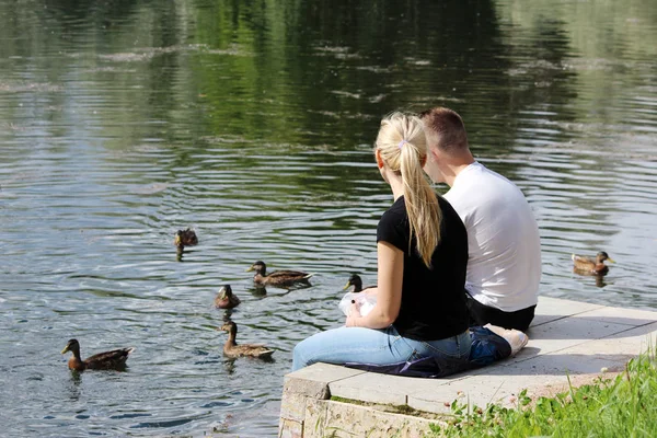 Junges Paar Sitzt Auf Einer Betonverlängerung Der Brücke Und Füttert — Stockfoto