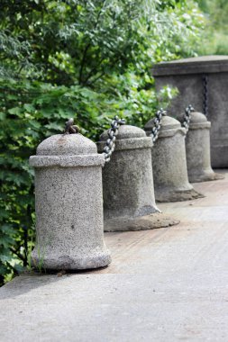 Yol köprüsünde metal zincirli tarihi beton sütunlar var.