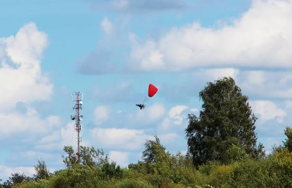 衛星放送やアンテナで塔の周りを飛ぶ危険なパラモーター — ストック写真