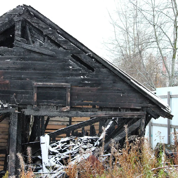 Черно-белое фото снежный заброшенный сгоревший деревянный дом . — стоковое фото