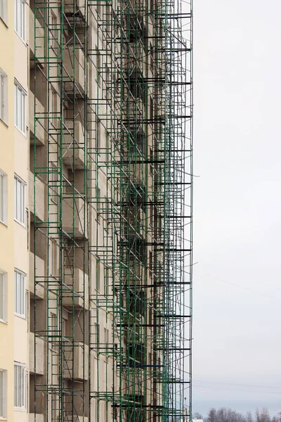 Zelená stavební kovové dřevo v béžové domě pod v době dokončování a omítání — Stock fotografie