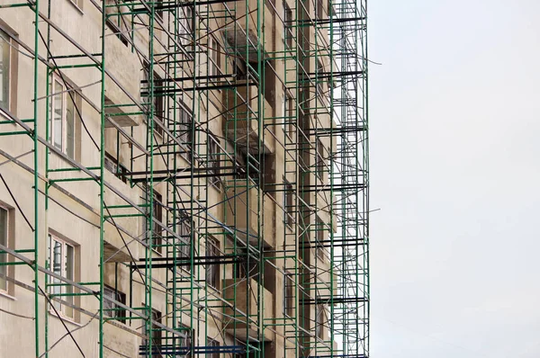 Groene metalen constructiehout in beige huis onder ten tijde van afwerking en stukadoors — Stockfoto