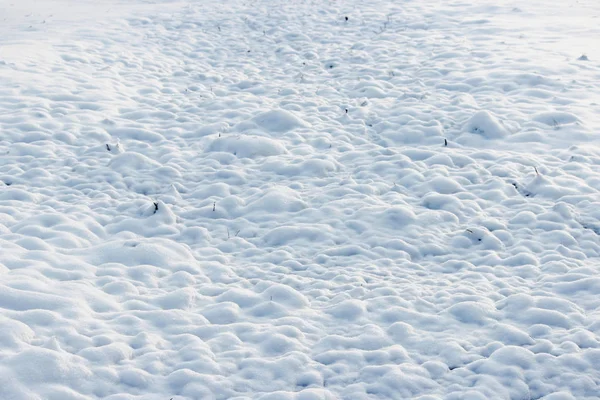 Konsistens av vit snö som små drivor som täckte jorden grävde — Stockfoto