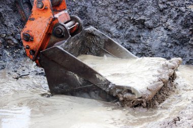 Yoğun bir yağmurdan sonra yolun inşaatı için alandaki bir hendekten su topluyor..