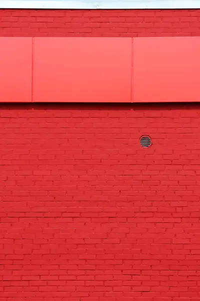 La textura de la pared de ladrillo rojo brillante con dosel y una pequeña rejilla de ventilación en el día soleado . — Foto de Stock
