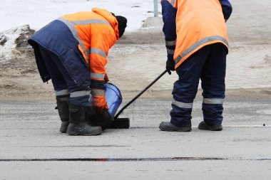 Tulum iki yol işçileri ile sıcak asfalt yol şerit kenarında yolun tamirinde dökülür
