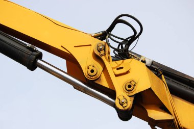 Demiryolundaki sarı yükleyici aygıtı. Gökyüzüne karşı hidrolik sistem