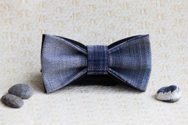 Kompozisyon: Siyah kareli bir kelebek ve bej arkaplanda küçük çakıl taşları ile gri.