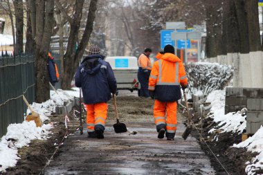 Çalışan taş ustaları kaldırımı tamir eder, yol için asfaltlama yapmadan önce kaldırımları kurar.