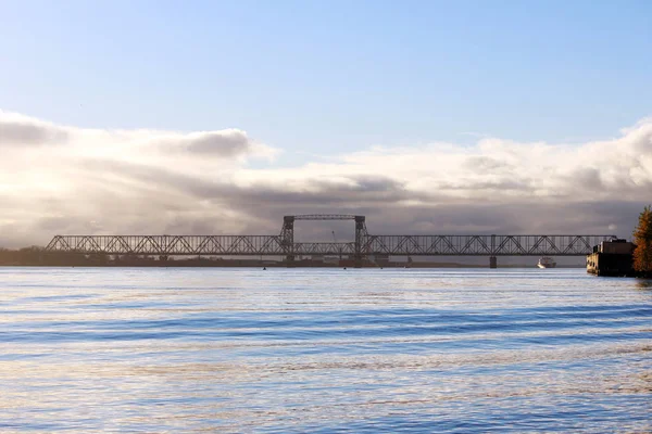 白い積雲の雲が北ドヴィナ川に架かる橋を渡す — ストック写真