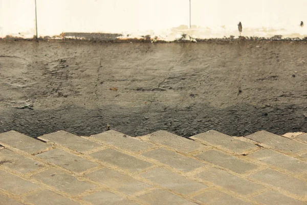 Asphalting of territory at a trading-office complex with the dismantling of paving slabs, which was laid before