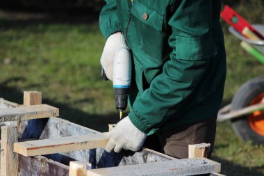 İşçiler beton ve kiremit dökmek için biçimlendirme yapıyorlar.