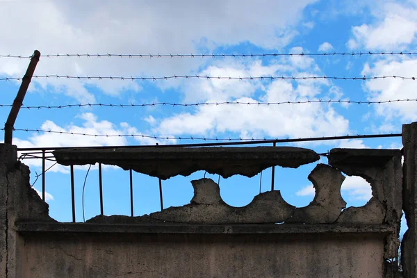 Ostnatý Drát Staré Betonové Zdi Střeží Objekt Pozadí Modré Oblohy — Stock fotografie