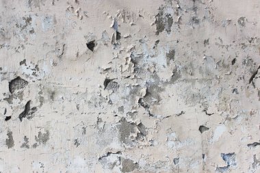 Arka planda alçı soyan eski bej duvar.