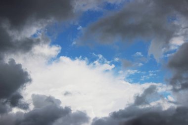 Büyük beyaz kümülüs bulutları mavi gökyüzüne karşı ilkbaharda yağmurdan önce bir lümen ya da çerçeve şeklinde