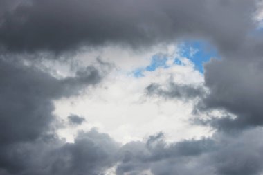 Büyük beyaz kümülüs bulutları mavi gökyüzüne karşı ilkbaharda yağmurdan önce bir lümen ya da çerçeve şeklinde