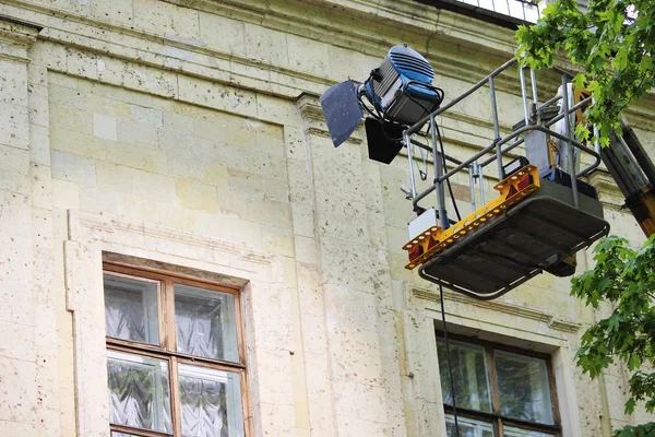 Een speciale projector op de lift licht het venster van het paleis van Gatchina bij het fotograferen van een speelfilm buiten het gebouw. — Stockfoto