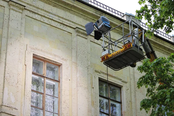 Ein spezieller Projektor auf dem Aufzug beleuchtet das Fenster des Gatchina-Palastes bei Dreharbeiten für einen Spielfilm außerhalb des Gebäudes. — Stockfoto