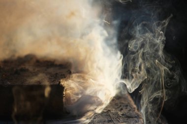 Islak tahtaların ve talaşların bulunduğu ateşten beyaz duman.