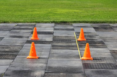 Plastik turuncu sinyal konileri ağırlık kaldırma yarışmasına hazırlanmak için stadyumda duruyorlar..