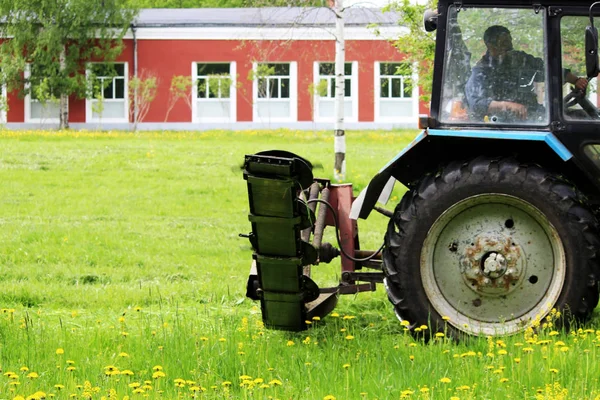 Traktor Speciálním Upevněním Automaticky Seká Trávu Pampelišky Městském Trávníku — Stock fotografie