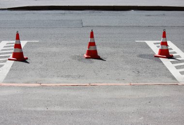 Plastik trafik konileri park yerinde araba için yer kaplıyor.