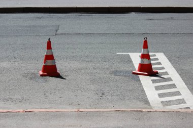Plastik trafik konileri park yerinde araba için yer kaplıyor.