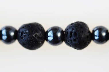 Siyah Vesuvius ve hematitten kalma kolye. Beyaz arkaplanda makro çekim.