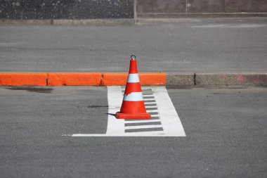 Plastik trafik konisi park yerinde araba için bir yer kapatıyor.