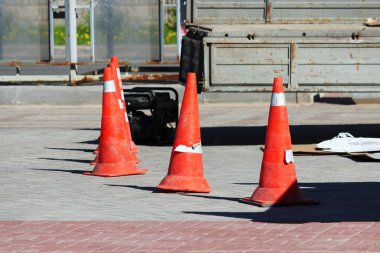 Plastik trafik konileri insanlardan vincin çalıştığı cam reklam standının kurulum noktasını sınırlıyor.