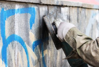 Bir yeraltı geçidine ait beton bir duvardaki duvar yazısının kaldırılması.