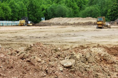 Traktör ve kompaktör tesviye ve dünya yüzeyinin sıkıştırma. Şehir Stadyumu inşaatı