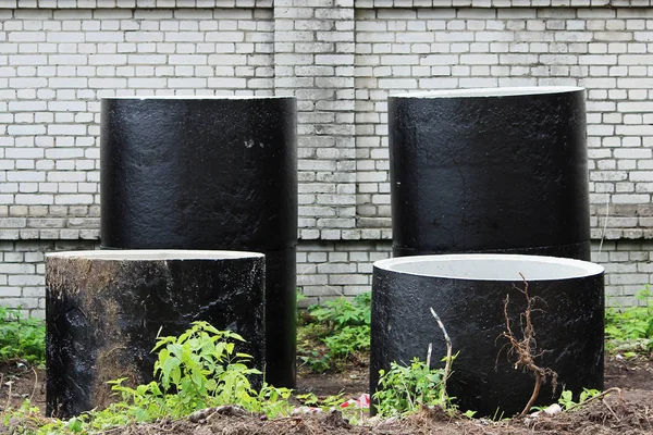 storm drains from concrete rings are in two rows near the construction site for the construction of a stadium.