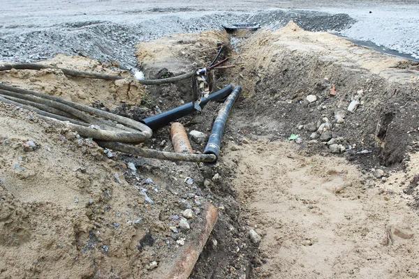 Protective PVC corrugated pipe with electrical cables inside, laid in the land when building a parking lot for tourist buses. in case of fire, the fire goes out and compressed.