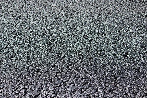 Tekstura świeży gorący czarny asfalt kładzie się na nowej drodze — Zdjęcie stockowe