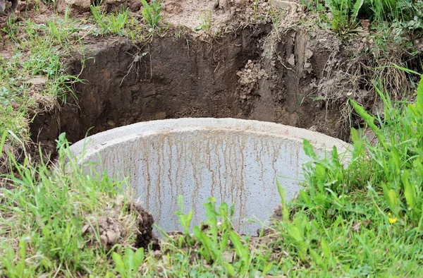 Well for water extraction. The construction of a village well for the extraction of water with the help of several concrete rings laid in a pit of earth