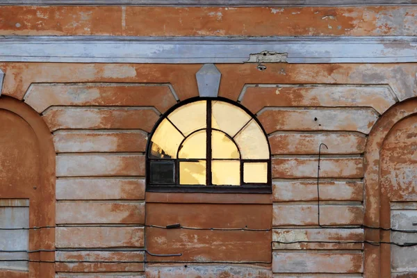 Свет солнца отражается в полукруглом окне исторического дома во время заката . — стоковое фото