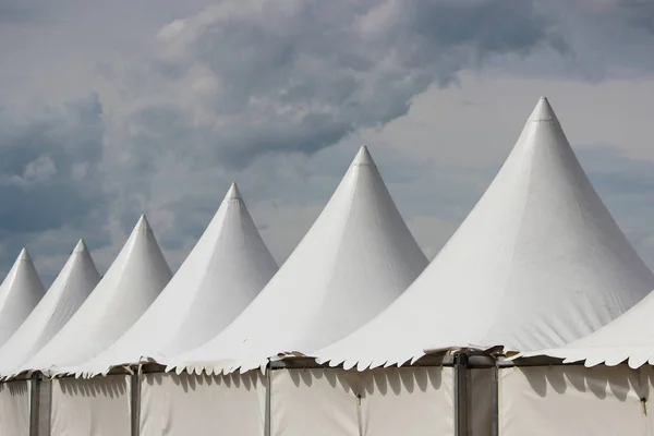 Festival white big tents near the park on holiday.